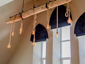 A rustic wooden beam with light bulbs hanging from it, suspended from the ceiling. - 3 Bed in Newquay (oc-90068) (Newquay)