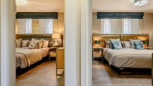 Une chambre aux murs recouverts de miroirs, avec deux lits, deux tables de chevet et deux lampes.