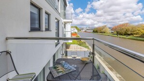 Ein Balkon mit Tisch, Stühlen und einer Zeitschrift.