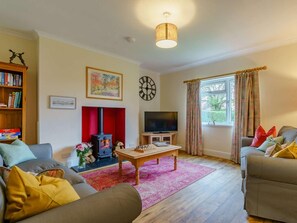 A living room with a fireplace, television, and seating area. - 3 Bed in Blairgowrie (oc-90111) (Blairgowrie)
