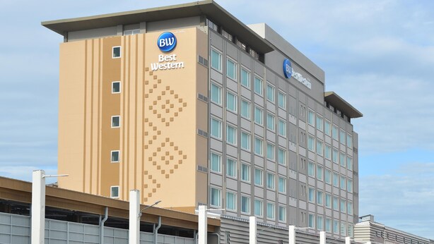 Un edificio de hotel con diseño moderno, que presenta un llamativo letrero de 'BW Best Western' en la fachada.
