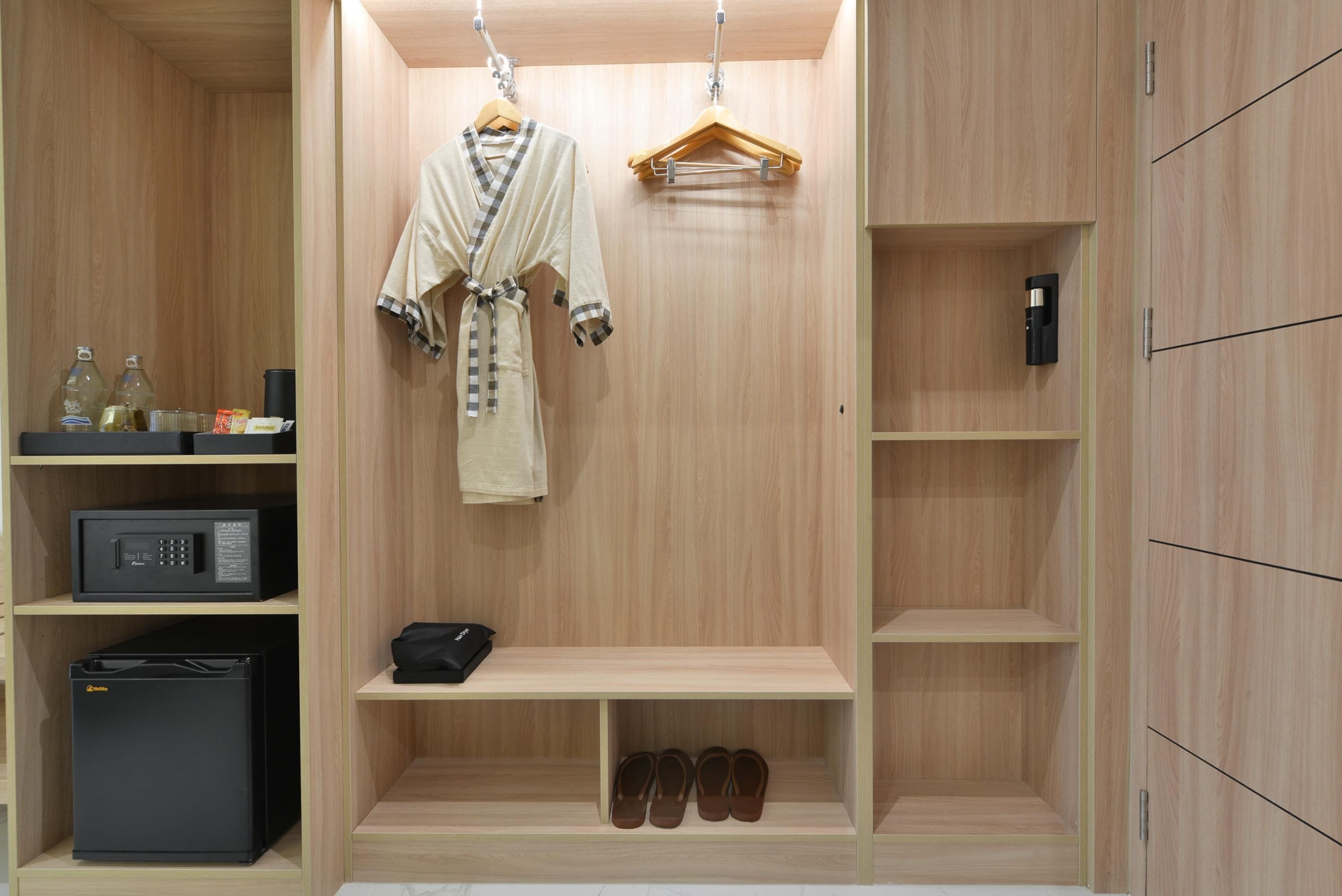 Un closet amplio con estantes de madera, un perchero, un microondas y un zapatero.