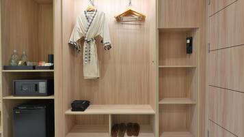 Un closet amplio con estantes de madera, un perchero, un microondas y un zapatero.
