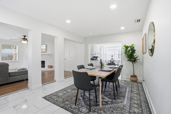 A modern dining area with a wooden table, black chairs, and a patterned rug. - Spacious and comfortable house in Avondale. Ideal for longer stays. Pet friendly (Jacksonville)