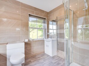 Ein modernes Badezimmer mit Toilette, Waschbecken und Duschbereich.