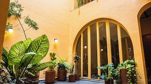 A building with large arched windows and potted plants in front. - Casa Juan Álvarez  (Guadalajara)