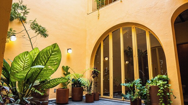 Un edificio con grandes ventanales arqueados y plantas en macetas al frente.