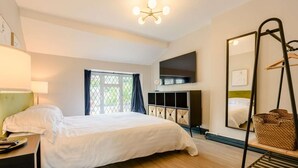 A bedroom with a bed, a TV, a mirror, and a window. - 2 Bed in Ilfracombe (oc-89570) (Combe Martin)