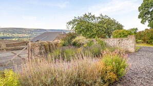 A stone wall, a wooden gate, and a garden with various plants and flowers. - 5 Bed in Crickhowell (oc-90053) (Glangrwyney)