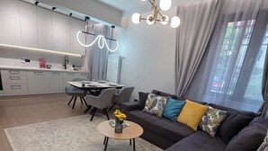 Um espaço de estar moderno com sofá, mesa de centro e área de jantar.