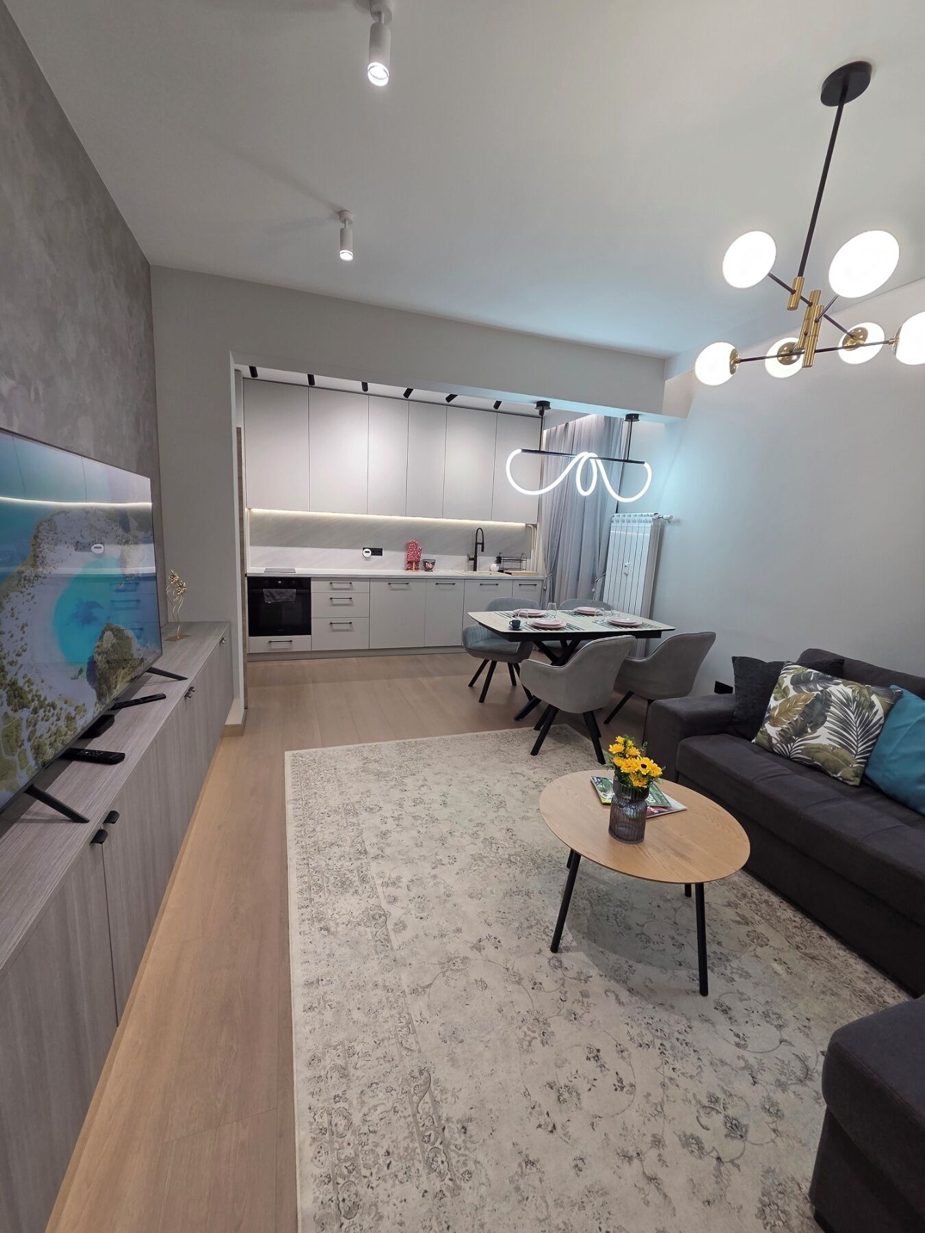 Een moderne woonkamer met een bank, salontafel en televisie.