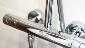 Uma torneira cromada com o logotipo GROHE, parte de um acessório de banheiro.