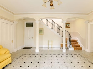 A spacious foyer with a marble floor, a staircase with a black railing, and a yellow sofa. - 2 Bed in Keswick (oc-89261) (Portinscale)