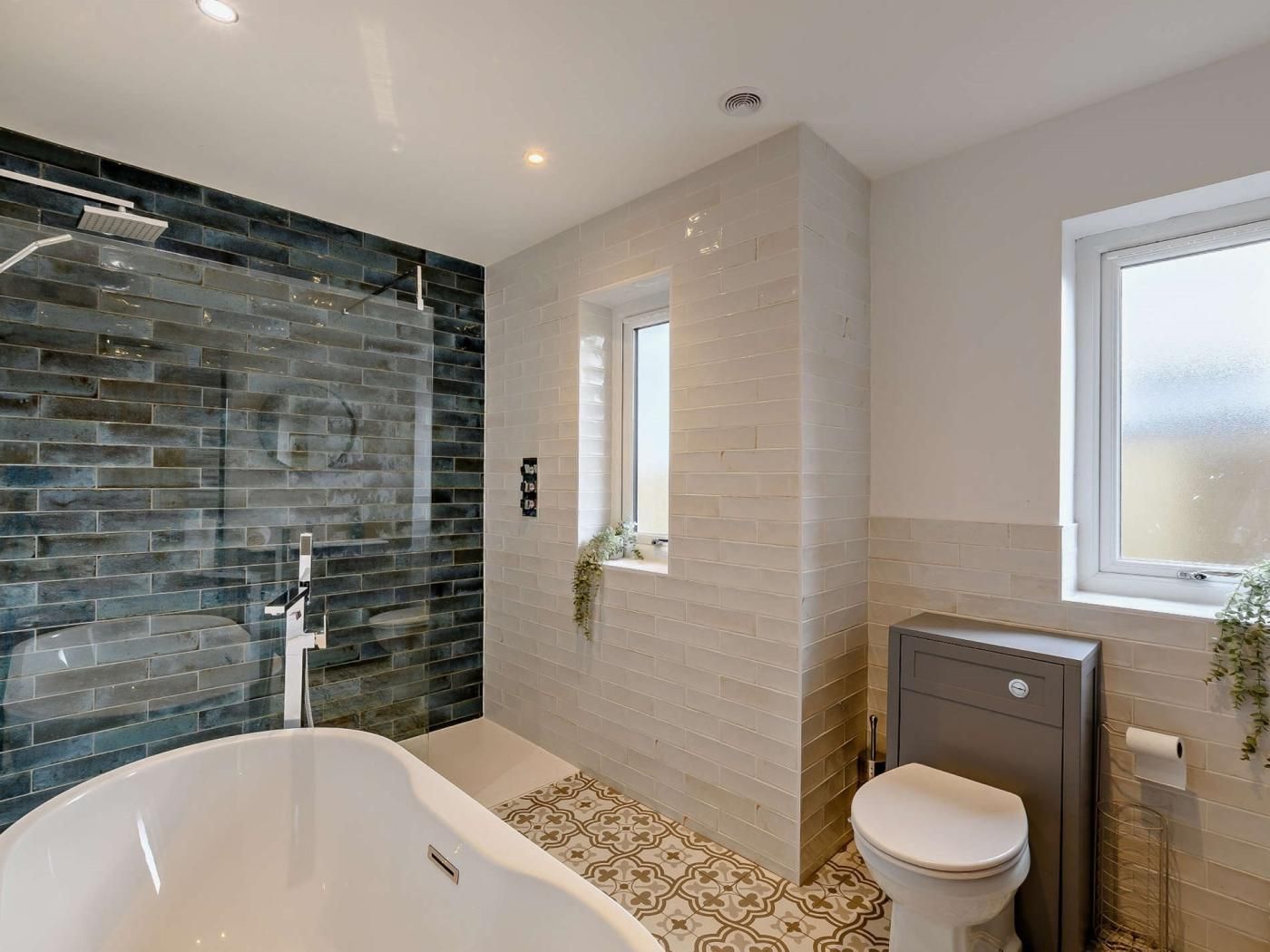 A modern bathroom with a freestanding bathtub, a toilet, and a shower area.