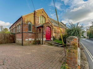 A brick building with a red door and a small set of steps leading to the entrance. - 3 Bed in Ventnor (oc-89800) (Ventnor)