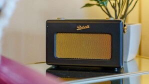 Rádio preto antigo com a marca 'Roberts' em uma superfície refletora.