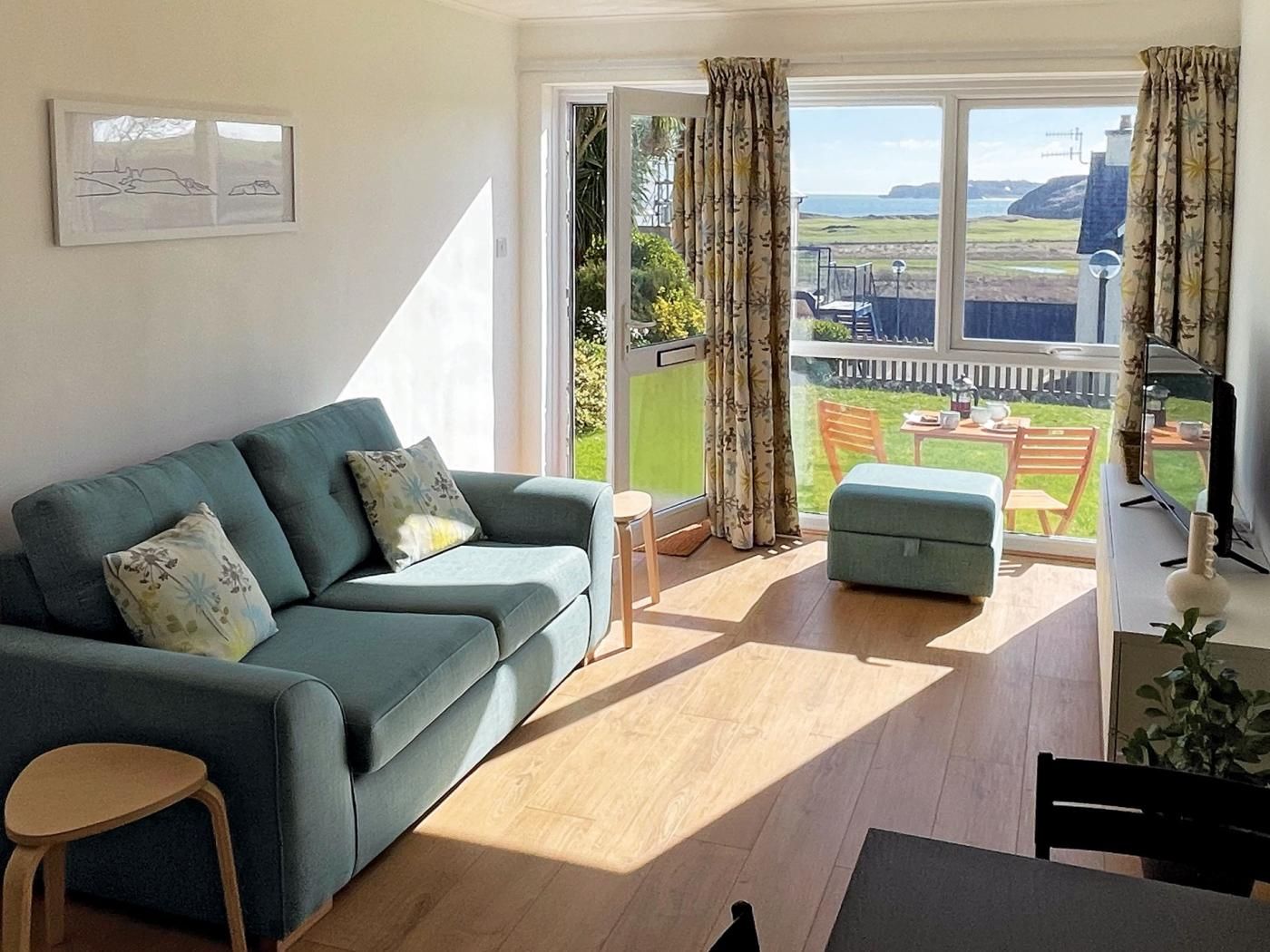 A living room with a sofa, a small table, and a view of the outdoors.