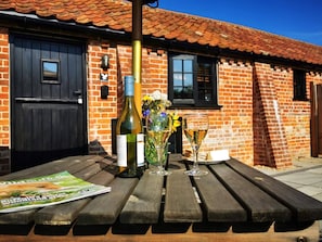 A wooden table with a bottle of wine, two glasses, and a magazine. - 1 Bed in Beccles (oc-90192) (Burgh Saint Peter)