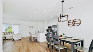 A modern living space with a dining area, kitchen, and seating area.
