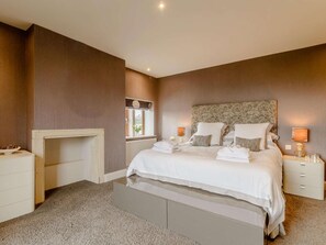 A bedroom with a bed, bedside tables, a nightstand, a window, and a fireplace. - 3 Bed in Halifax (oc-90209) (Sowerby Bridge)