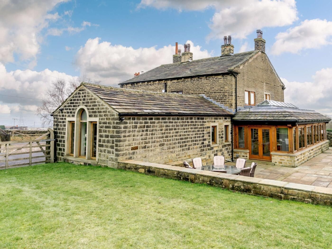 Une maison en pierre dotée d’un grand patio et d’une véranda.