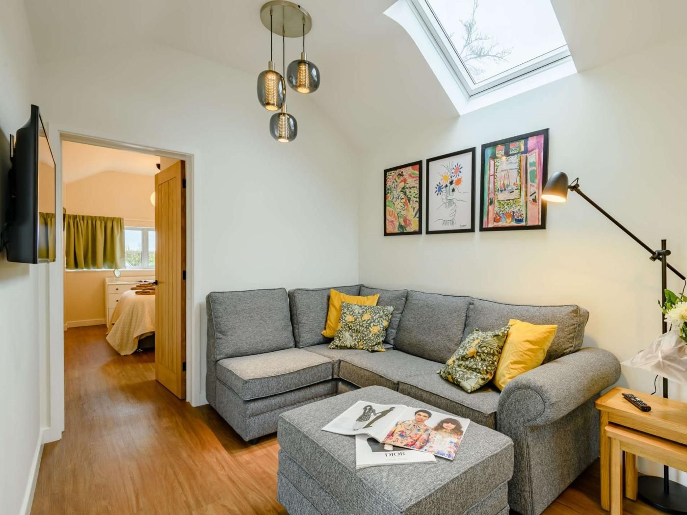 A modern living room with a sectional sofa, a small table, and a reading area.