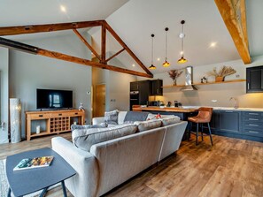 A modern living room with a sofa, a TV, and a wooden entertainment unit.