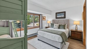 A bedroom with a bed, two bedside tables, a window with a view, and a framed picture on the wall. - Cedars Retreat - Walk to Main St & Trails & Pool (Breckenridge)