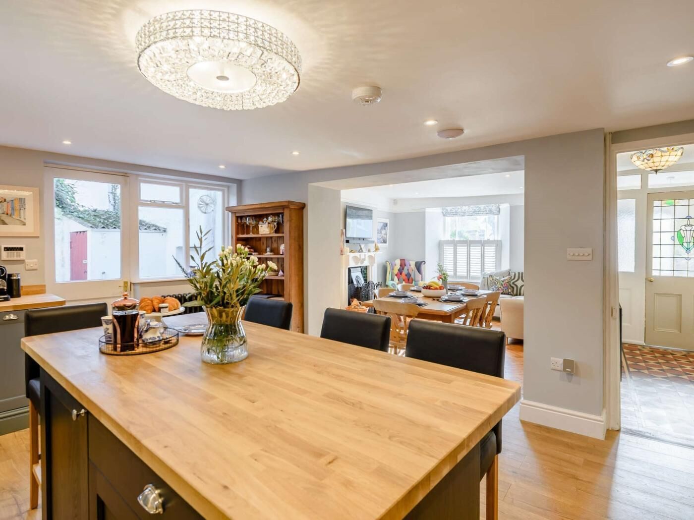 Una cocina amplia con una mesa de madera, una araña y vista al área de comedor.