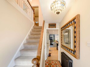 Un escalier avec une rampe en bois menant à une cuisine.