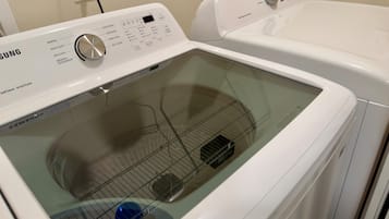 A Samsung self-cleaning smart care washing machine with a control panel and a transparent door.