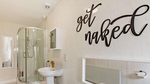 Ein modernes Badezimmer mit einer Duschkabine aus Glas, einem Standwaschbecken und einer großzügigen Badewanne.