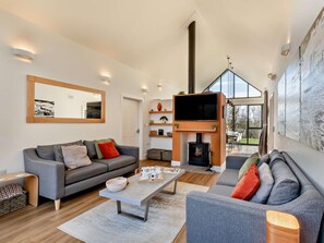 A modern living room with a sofa, a coffee table, a fireplace, and a television. - 3 Bed in Bamburgh (oc-90062) (Bamburgh)