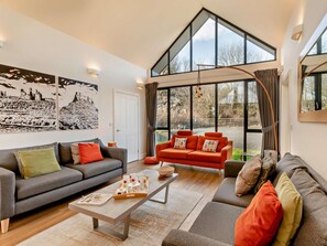 A modern living room with a grey sofa, a red sofa, and a coffee table with a tray of items. - 3 Bed in Bamburgh (oc-90062) (Bamburgh)
