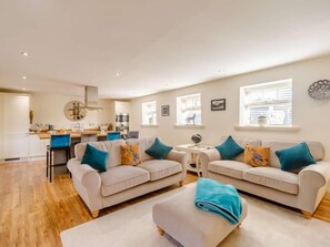 A modern living room with two sofas, a coffee table, and a dining area with a kitchen in the background. - 2 Bed in Rowlands Gill (oc-89758) (Lintz Green)