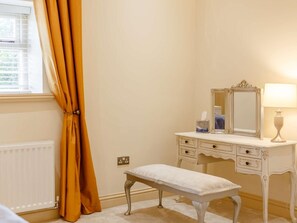 A room with a vanity, a bench, a mirror, and a window with curtains. - 2 Bed in Rowlands Gill (oc-89758) (Lintz Green)