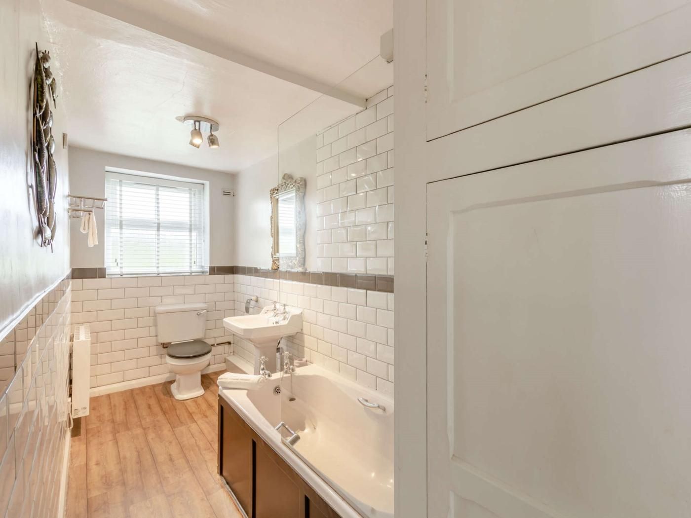 Et badeværelse med toilet, håndvask og badekar.