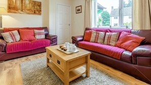 A living room with two leather sofas, a wooden coffee table, and a painting on the wall. - 2 Bed in Hexham (oc-89299) (Kielder)