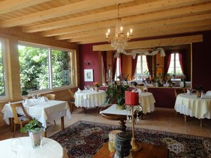 A dining area with wooden beams, chandeliers, and tables set for dining. - Auberge Ramstein (Scherwiller)