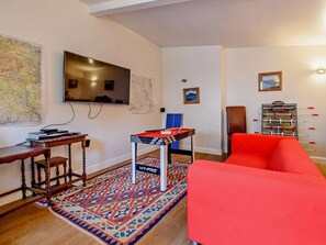 A living room with a sofa, a TV, a map, a table, and a foosball table. - 3 Bed in Buxton (oc-90125) (Hartington)