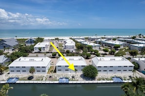 A coastal hotel with multiple buildings, a pool, and a view of the ocean. - Chic Canalside Condo, Steps from Beach & Pool (Sanibel)