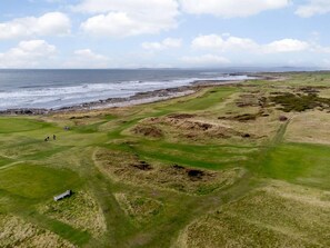En kystgolfbane med udsigt over havet og en klippefyldt kystlinje.
