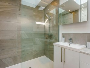A modern bathroom with a glass shower enclosure, a white sink, and a mirror above the vanity. - 1 Bed in Broadstairs (oc-89391) (Broadstairs)