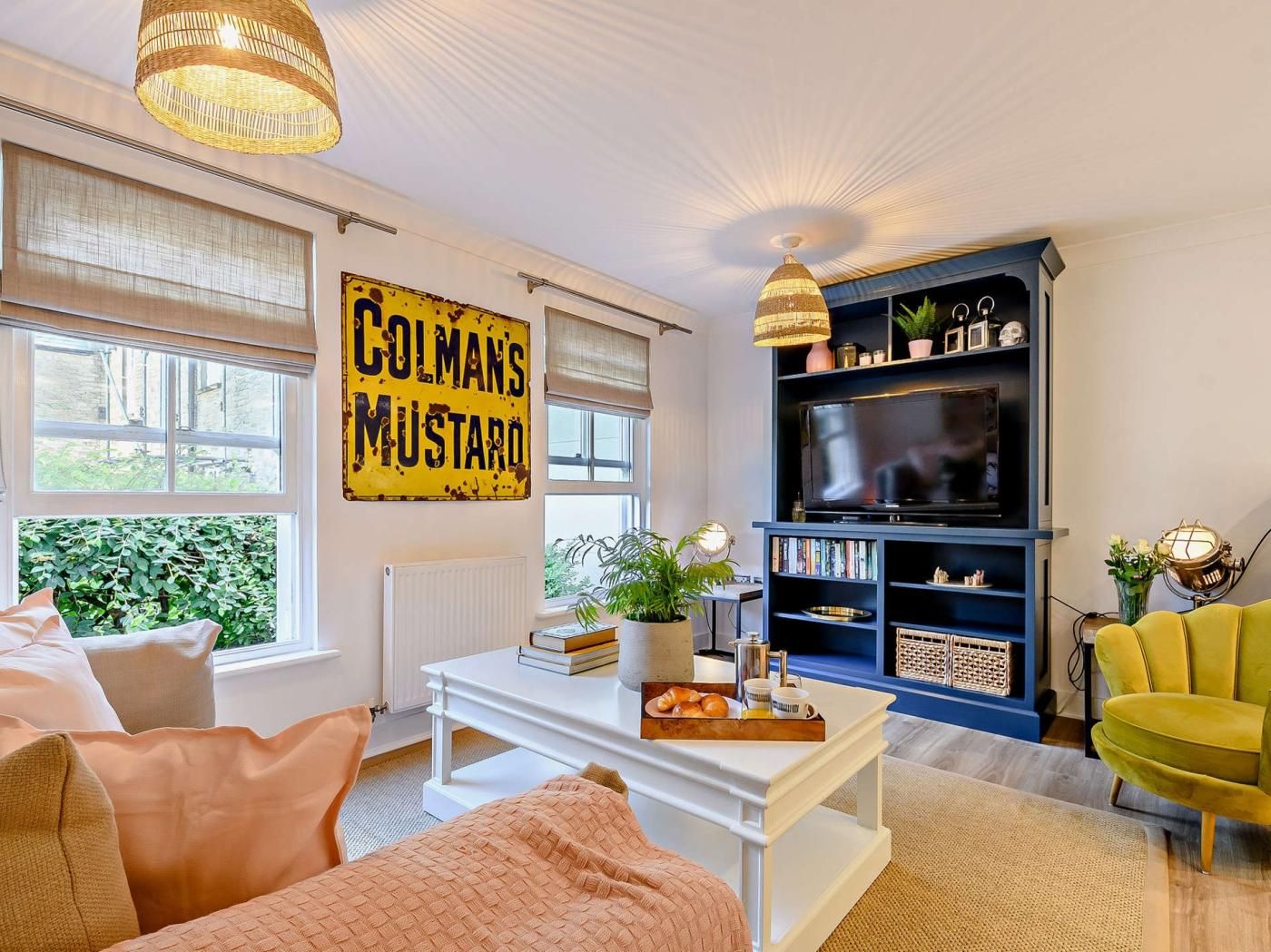 Ein Wohnzimmer mit Fernseher, Bücherregal und einem Schild, auf dem 'Colman's Mustard' steht.