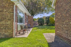 A brick house with a patio, a table, and chairs. - 2 Bed in Norwich (oc-89640) (Mundesley)
