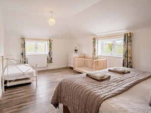 A bedroom with a bed, a crib, a dresser, and a window with curtains. - 3 Bed in Newport (oc-90246) (Newport)