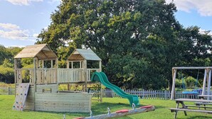 A playground with a slide, climbing wall, and seesaw. - 3 Bed in Newport (oc-90245) (Newport)