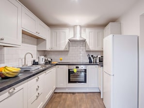 A modern kitchen with white cabinets, a stainless steel oven, and a refrigerator. - 2 Bed in Newport (oc-90244) (Newport)
