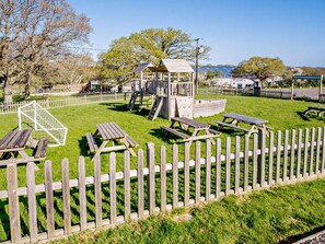 A playground with a climbing structure, picnic tables, and a fenced area. - 2 Bed in Newport (oc-90244) (Newport)