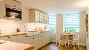 Uma cozinha moderna com armários brancos, forno embutido e um balcão de refeições rápidas.